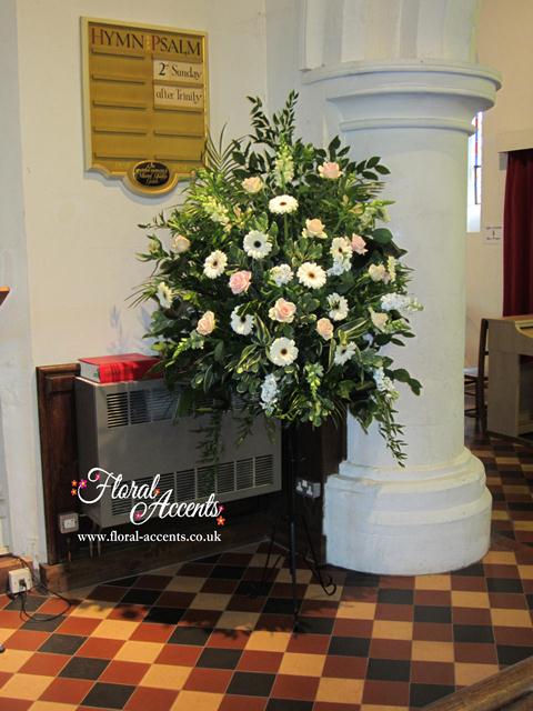Church pedestal arrangement - of cream Gerbera, soft pink Sweet Avalanche roses, white stocks, white snapdragon, pale pink alstromeria and assorted foliage