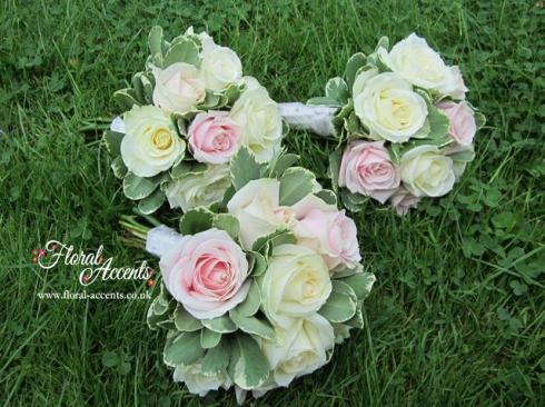 Handtied bridesmaid bouquets of soft pink Sweet Avalanche and ivory cream Avalanche roses and variegated pittosporum